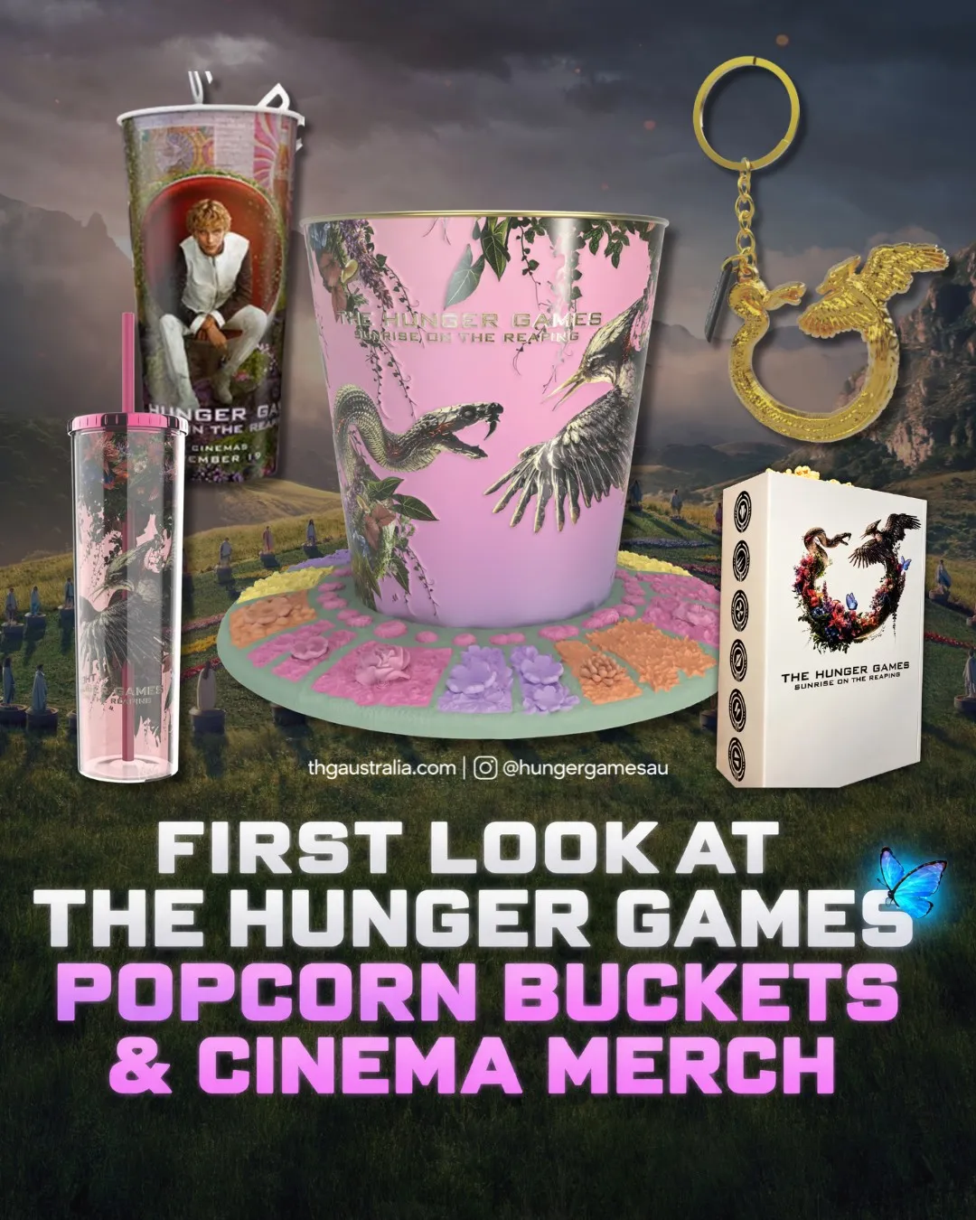 The full line-up of Sunrise on the Reaping cinema collectables against the meadow arena: Event's Haymitch cup, Village's pink tumbler and floral-base tub, the gold flint striker key chain and the white HOYTS tin with district emblems down its side.