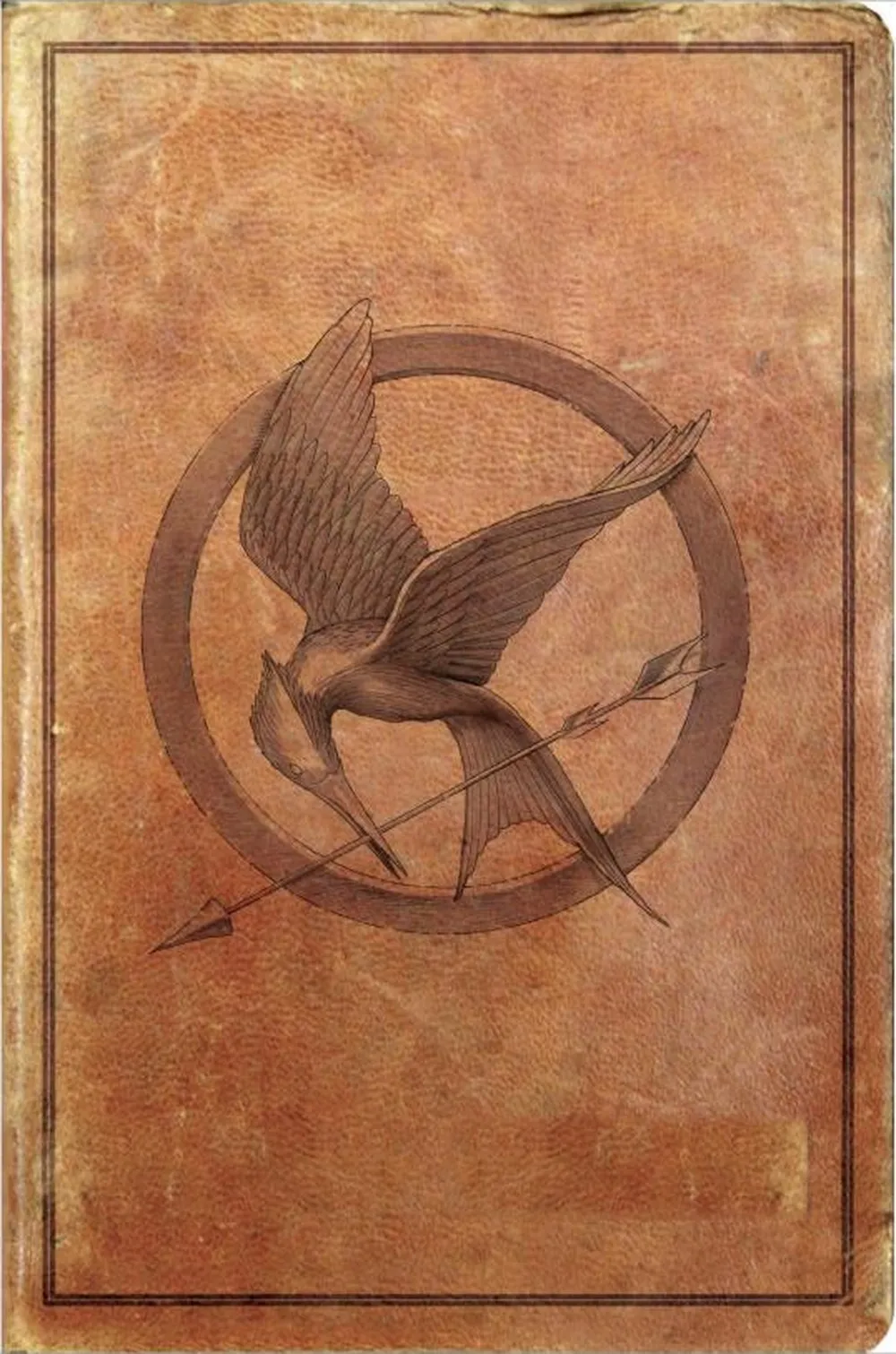 The front cover of The Hunger Games: Survival Edition — a distressed tan leather-look board with a tooled mockingjay roundel and no title
